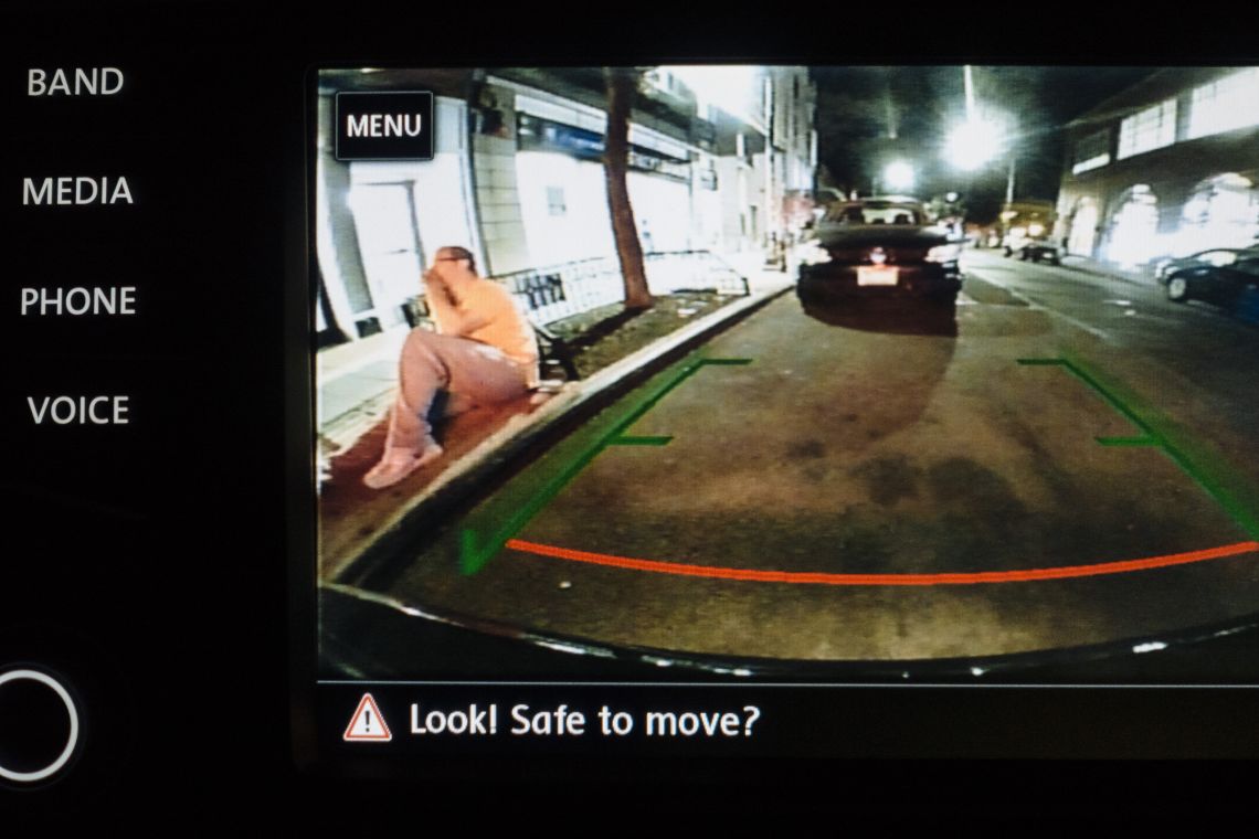 Man on curb, drunk, and leering.