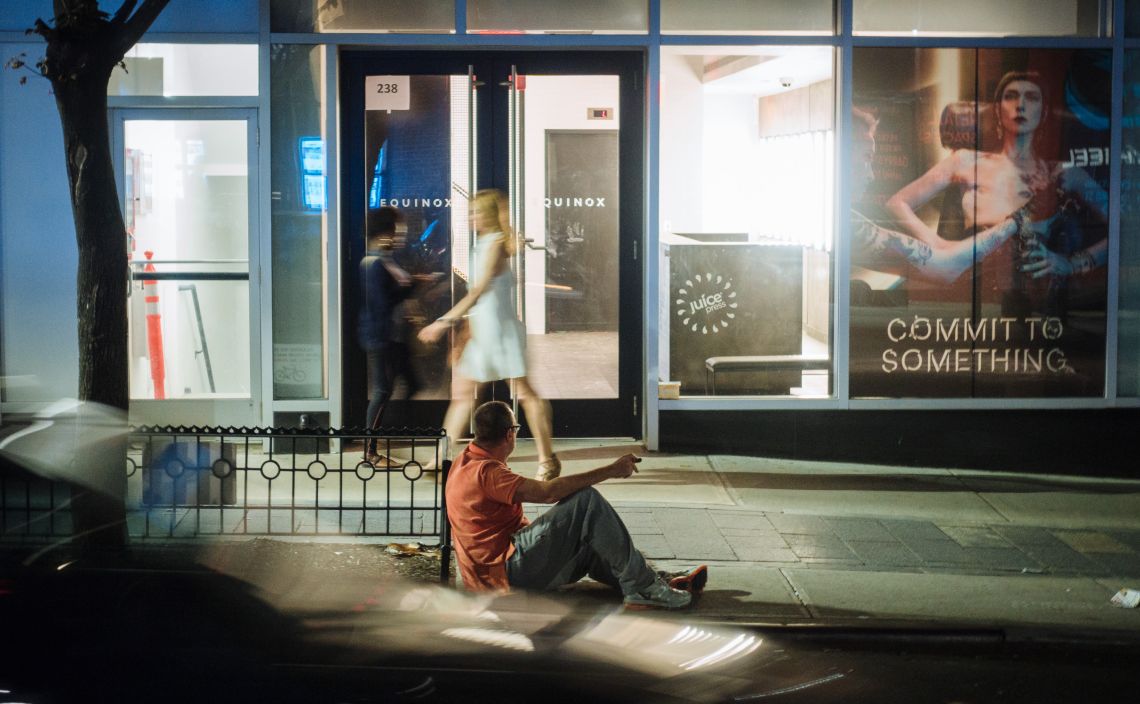Man on curb, drunk, and leering.