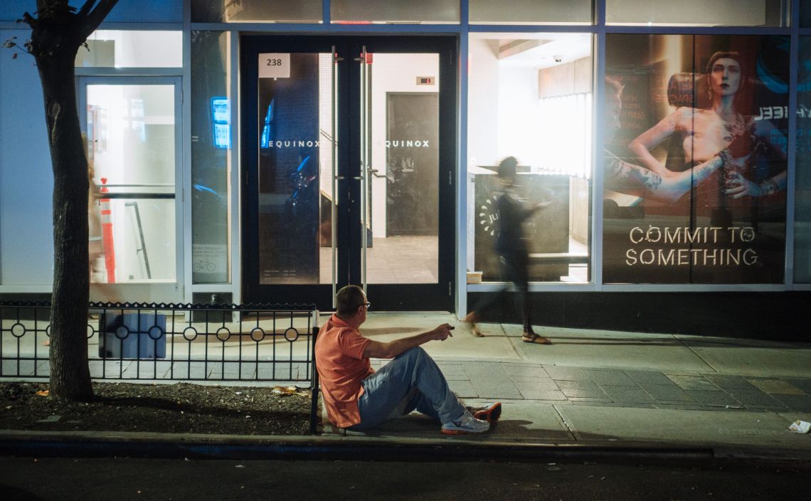 Man on curb, drunk, and leering.