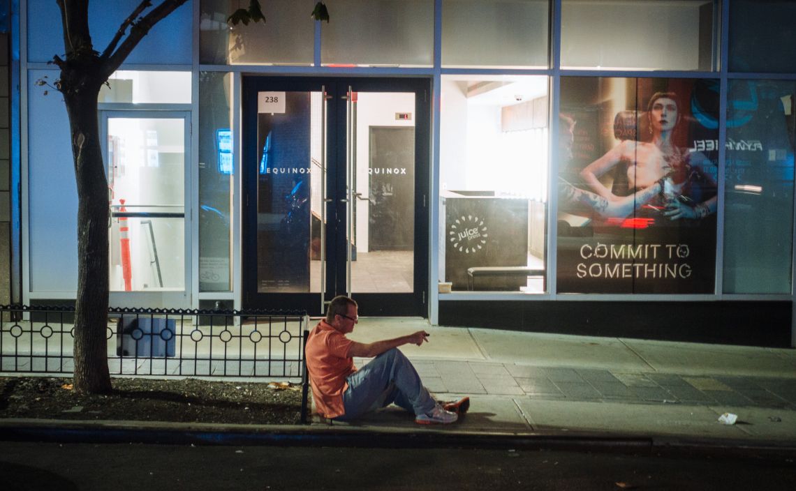 Man on curb, drunk, and leering.