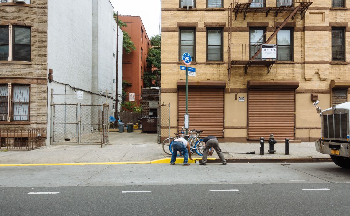 men painting curb in bed-stuy