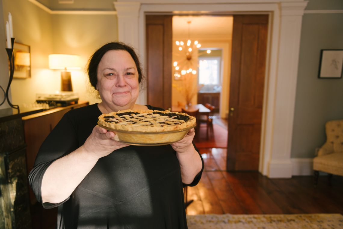 woman holding and offering pie