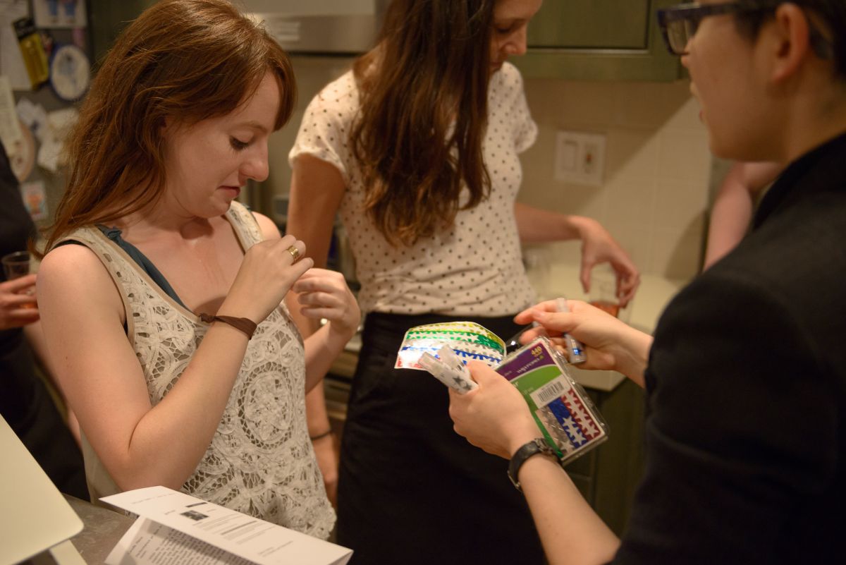 A guest dons a color-coded star, The host tags with a guest with a gold star, signifying pheromone she was sprayed with.