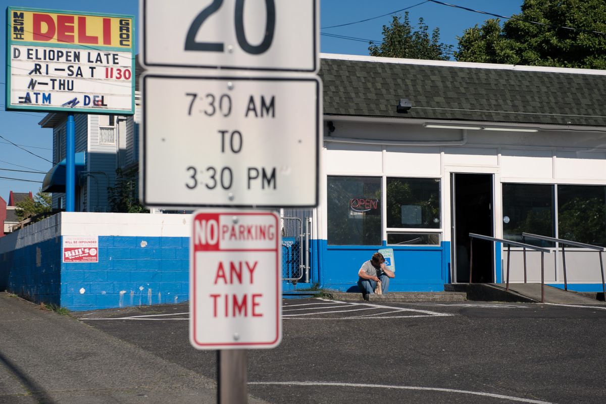A man sits on a curb.