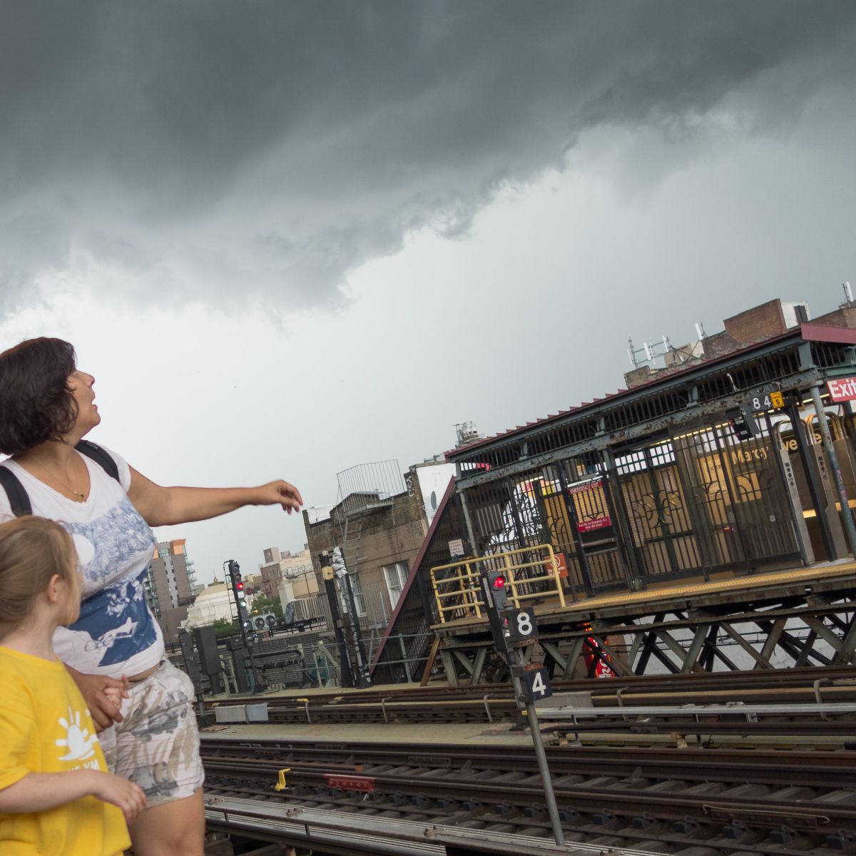 woman and child looking at storm clouds subway