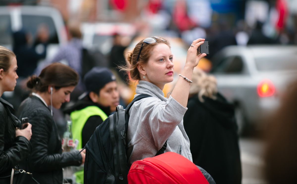 Man documenting the May Day March long 2nd Avenue