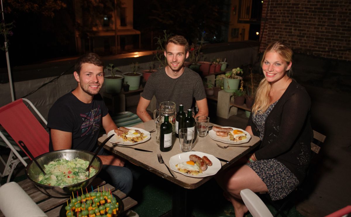 Surfers having a German dinner al fresco on the roof