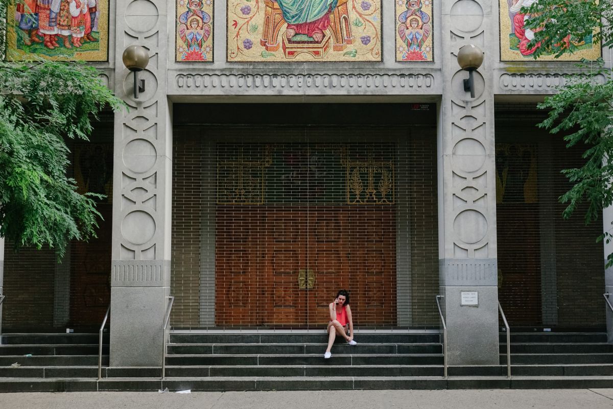 Young woman on the phone seated at the foot of the Lord