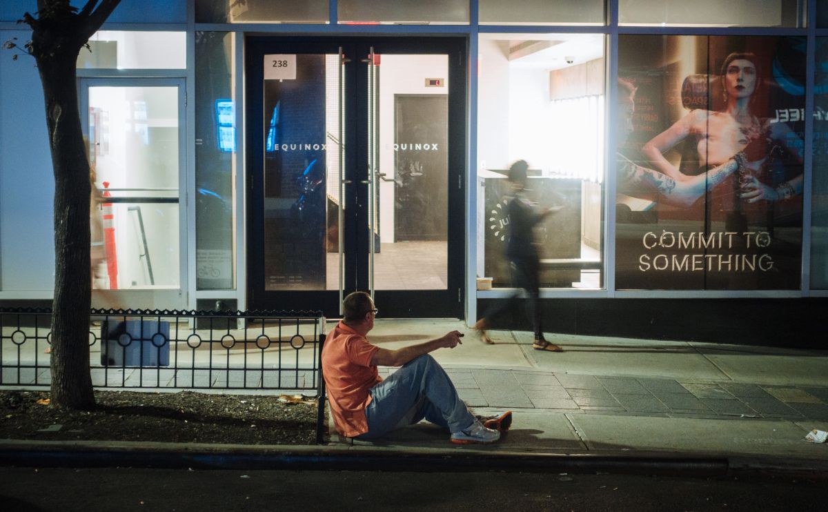 Man on curb, drunk, and leering.