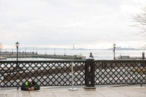 Security guard texts in the Battery Park Esplenade
