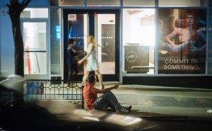 Man on curb, drunk, and leering.