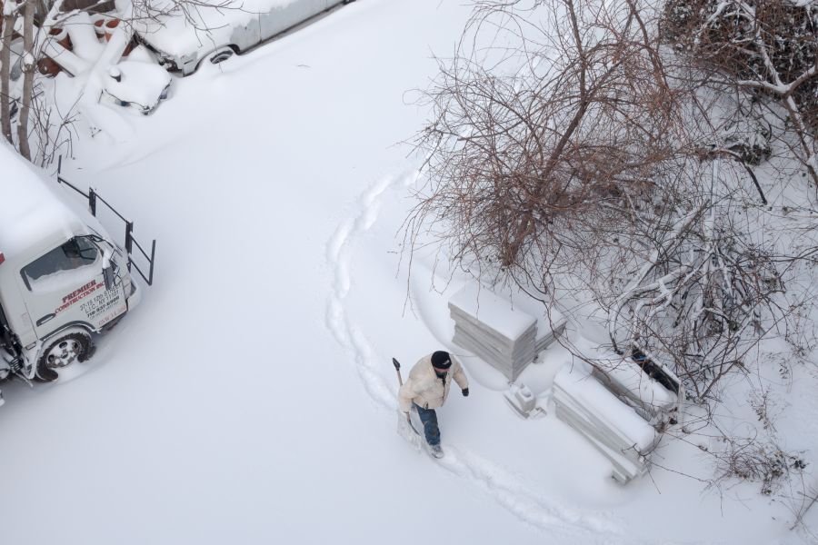 In the parking lot below, a man about to shovel snow