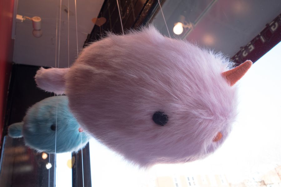 Two suspended, stuffed, fluffy narwhals