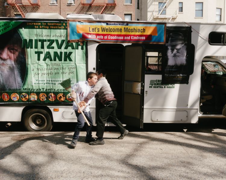 Two kids wrestle for control of a broom in Greenwich Village.