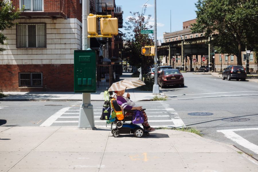 Woman in electric wheelchair with shade umbrella